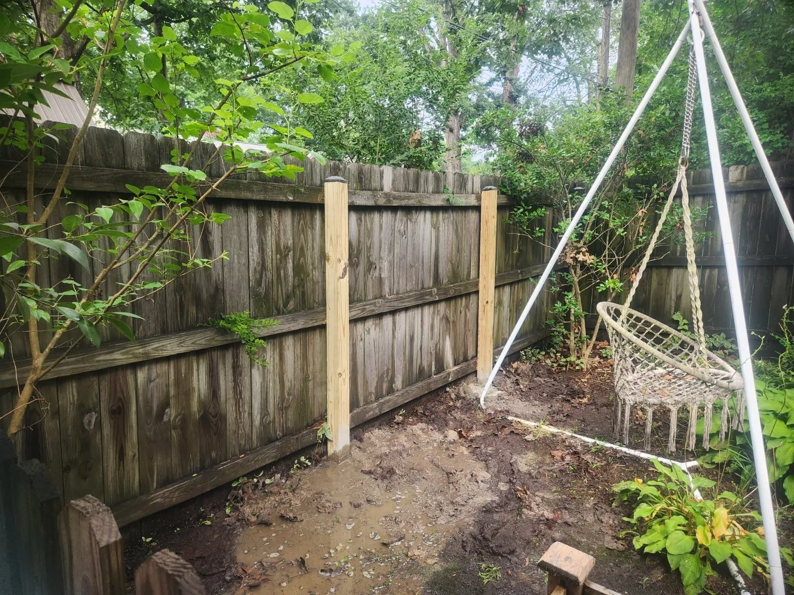 Partially dismantled wooden fence with new posts added, showing how to remove old fencing before replacement or repairs.