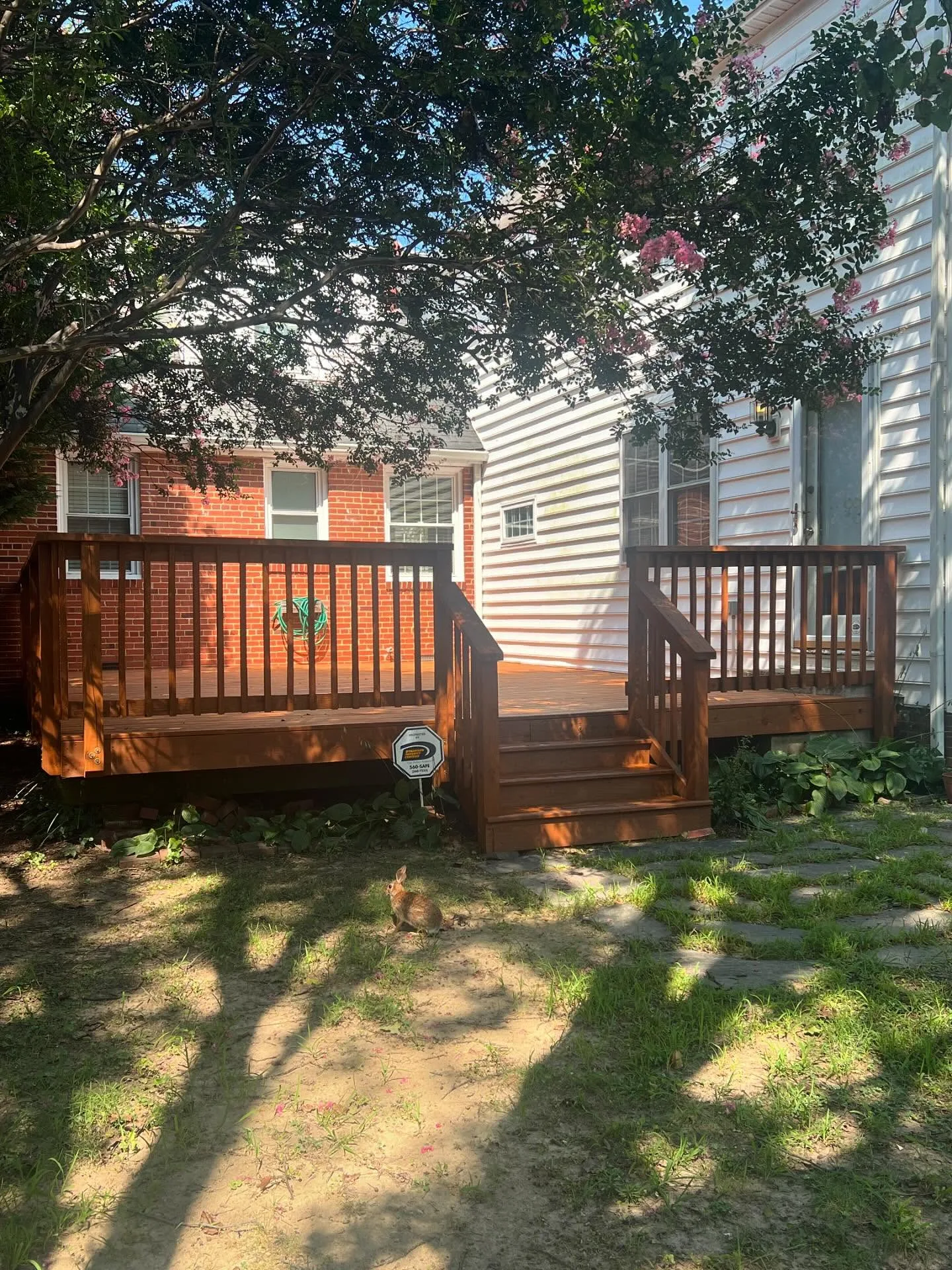 Small backyard deck design with wooden railings and stairs, built to maximize outdoor living space in a compact yard – Chesterfield Fencing, Virginia Beach.